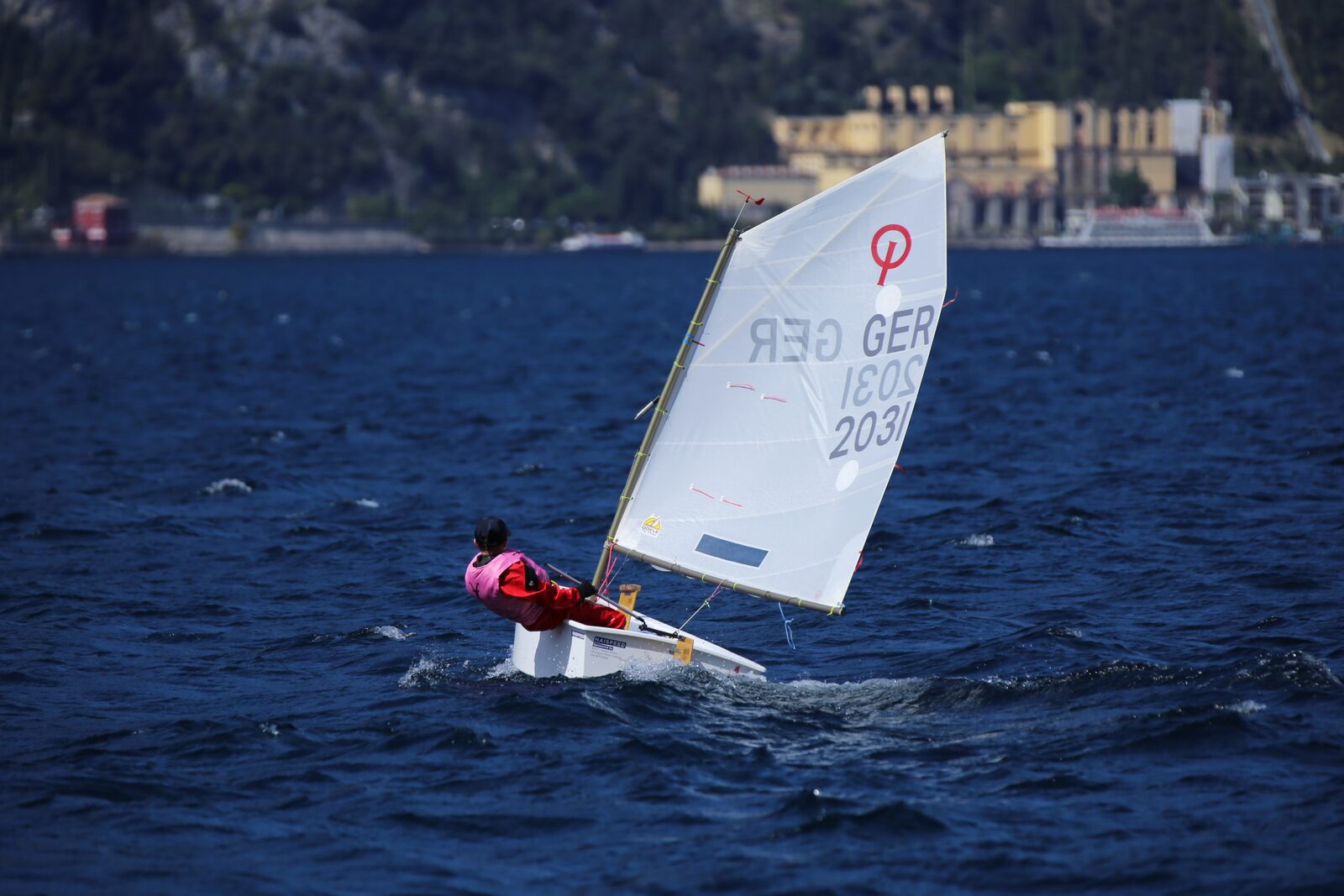Junger Segler im Optimisten bei kräftigem Wind
