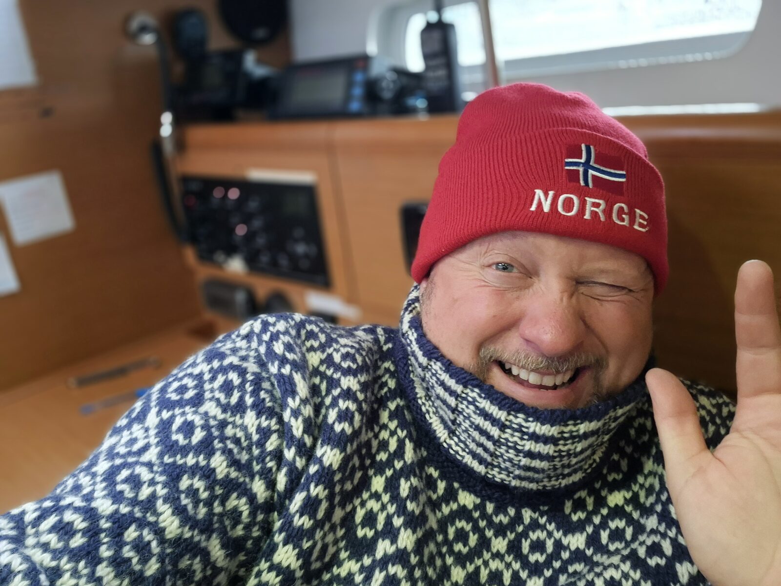 Nils-Peter Hey mit Wollpullover und Norwegen-Mütze in der Kajüte